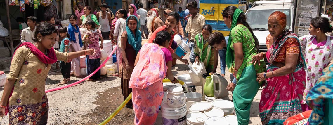 Women getting water from distribution truck in Delhi, India