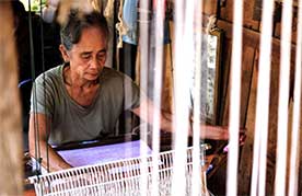 Chanthone Phanyphit, 71, a skilled weaver, meticulously crafts intricate patterns on her loom