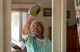 Domestic worker washing window_Johannesburg. Photo: J. Torgovnik/Getty Images