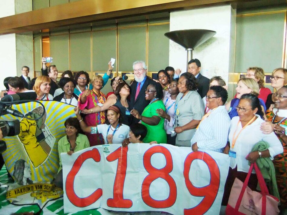 Group of domestic workers celebrating with ILO Director General Juan Somavía after Convention 189 adoption in 2011.