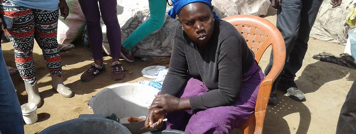 Coura Ndiaye, a leader of Bokk Diom, washing bottles at the Mbeubeuss dump in Dakar, Senegal in January 2017