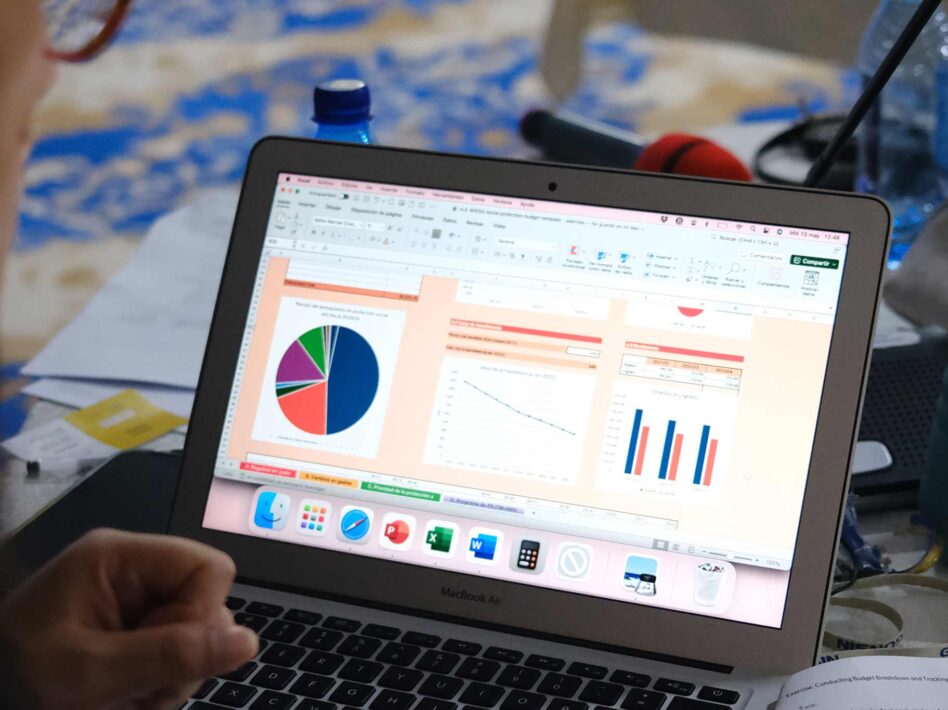 Close-up of a laptop screen showing the Social Protection Financing Calculator with charts and graphs for financial data analysis