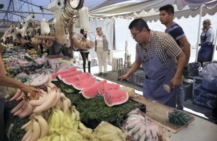 A street vendor in Mexico City prepares fresh watermelon and bananas for customers at a bustling outdoor market