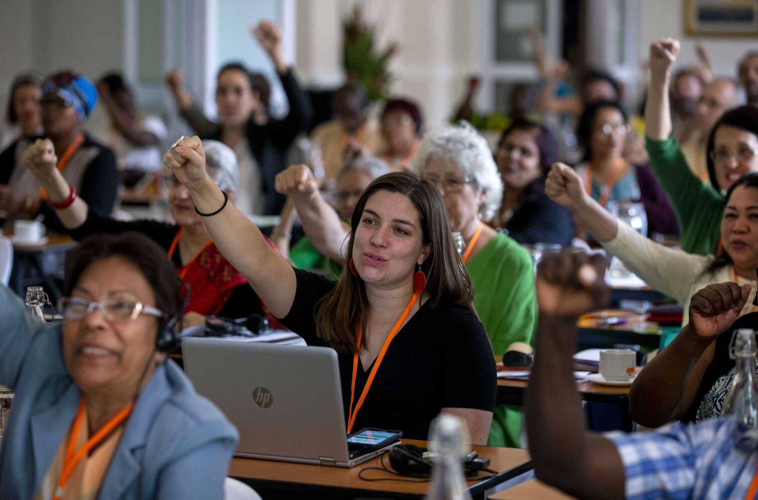 Participants at WIEGO’s 2018 General Assembly in Johannesburg, South Africa, raise their fists in solidarity during a session.