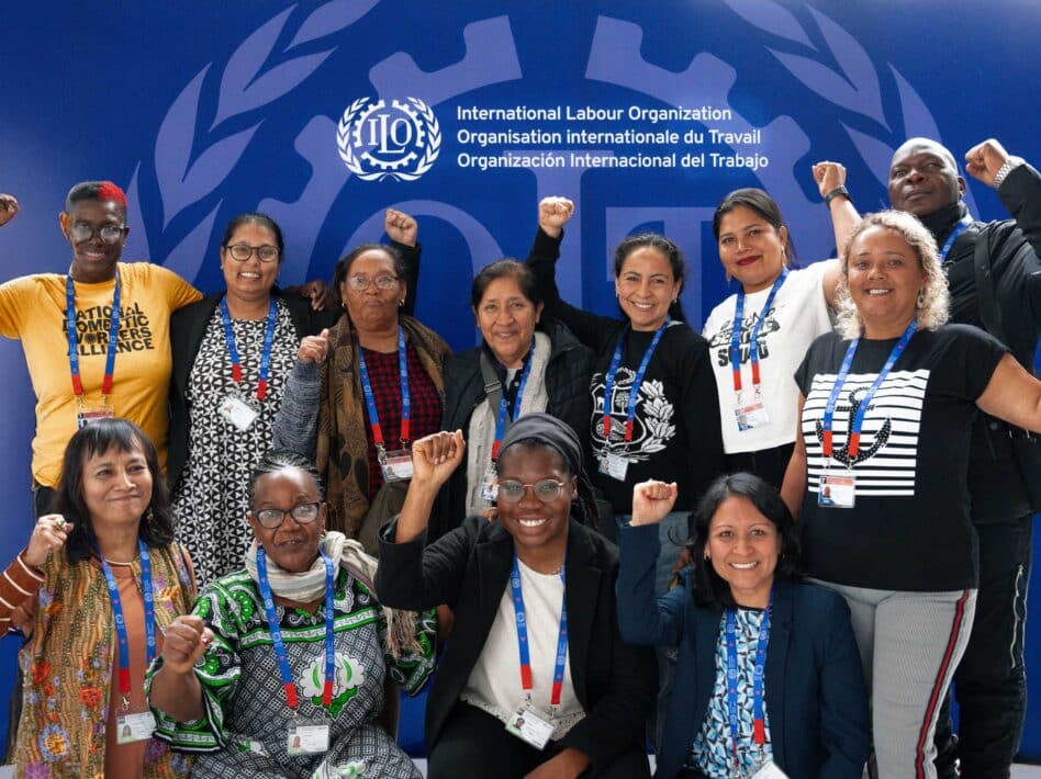 Worker leaders from the International Domestic Workers Federation, HomeNet International, and WIEGO raise their fists at the 2024 International Labour Conference.