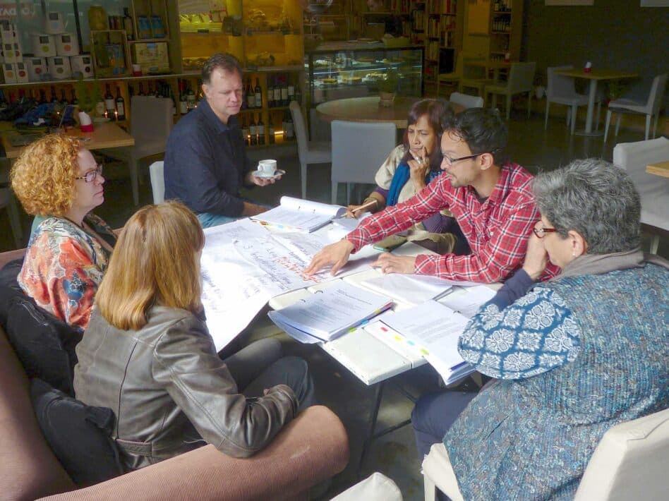 A group of people discussing documents at a negotiations training workshop in Buenos Aires.